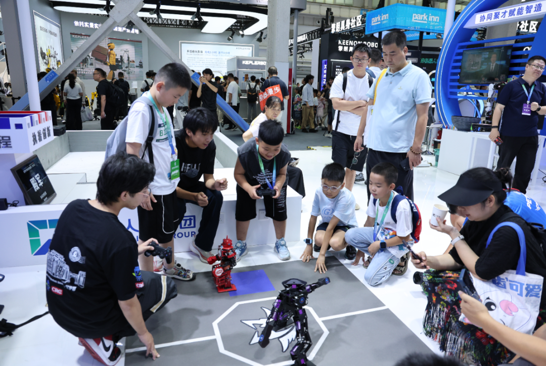 Visitors gather around to watch humanoid fighting robots compete at the World Robot Conference 2026 booth