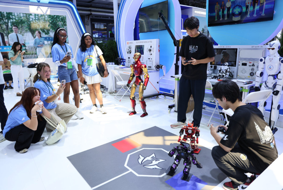 Students control humanoid fighting robots with game controllers at World Robot Conference 2026